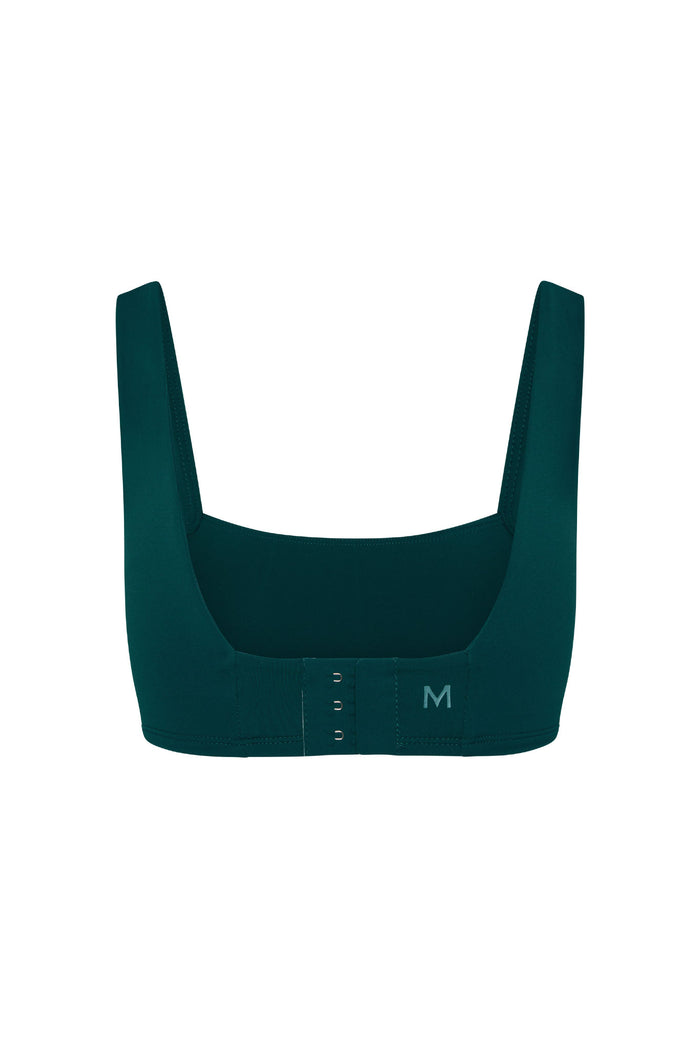 Back view of Zion Bra in evergreen with hook-and-eye closure, wide straps and M logo on white