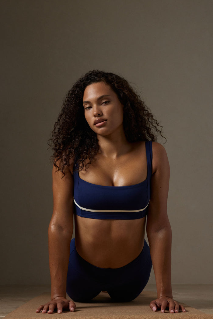 Front view of Zion Bra in midnight with ivory stripe showing square neckline, wide straps, and supportive band on model