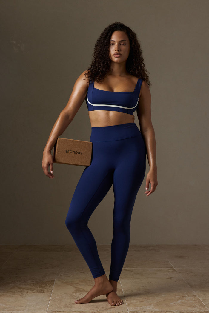 Front view of Zion Bra in Midnight with ivory trim on model, square neckline and wide straps against neutral studio background