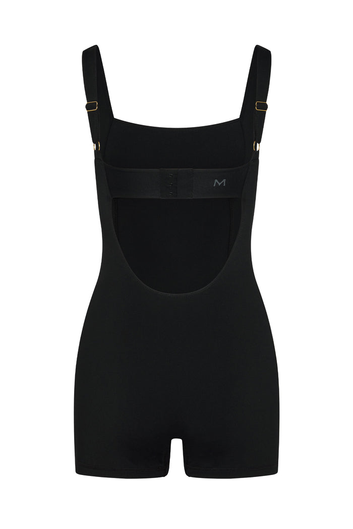 Back of Zion Romper in Black/Ivory with low scoop back, adjustable straps, hook back band and small M logo on white backdrop