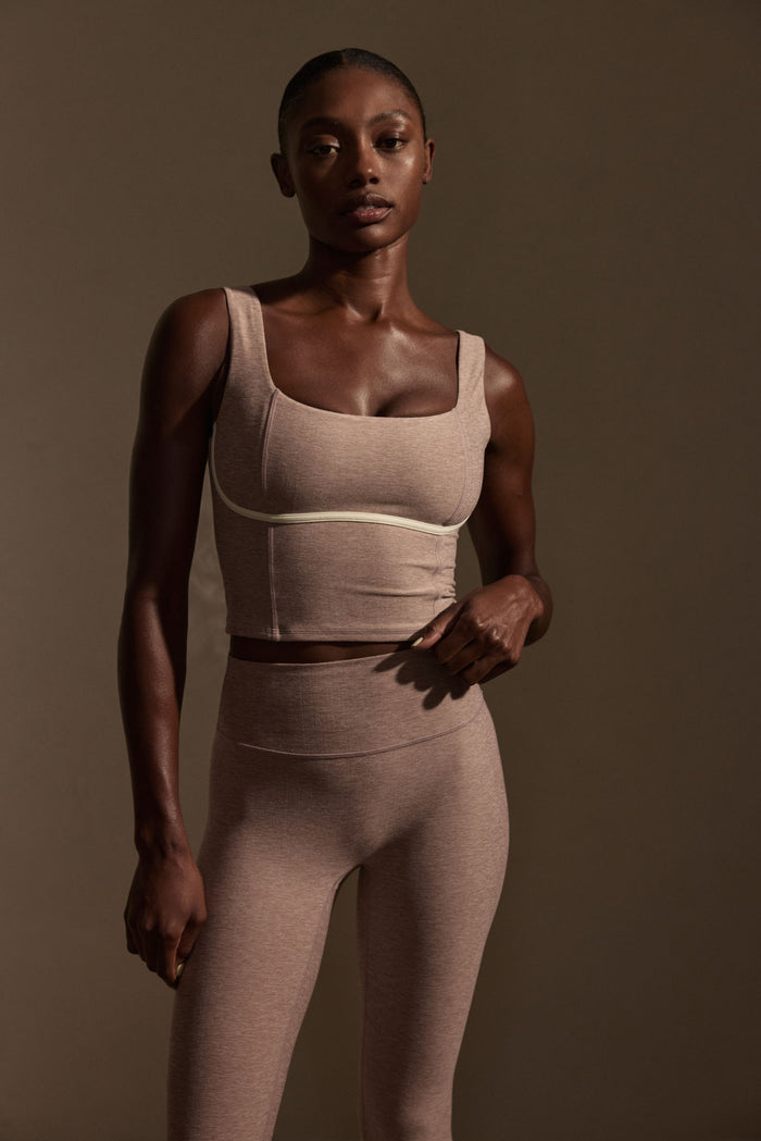 Front view of Acadia Legging in Heather Mauve on model showcasing high-rise waistband and smooth fit against brown background