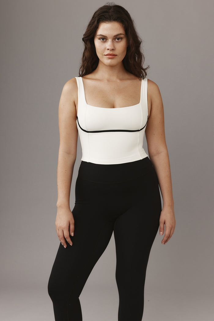 Front view of Zion Tank in Ivory/Black showcasing square neckline, cropped length, and black underbust piping on gray background