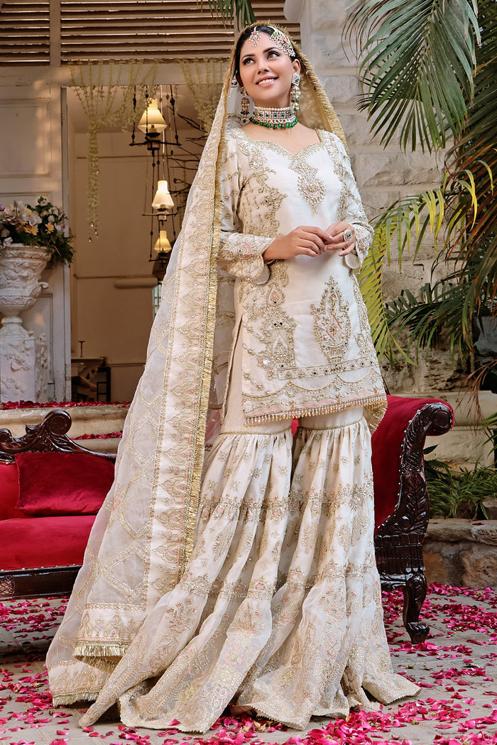 Macro of Zonar shirt bodice revealing dense naaḳshi-dabka embroidery with mirror and moti detailing against sheer organza.