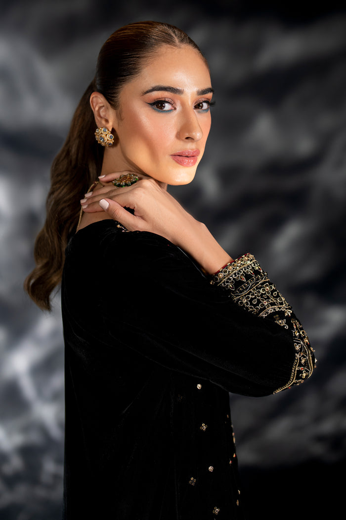 Model wearing full NAQSHI Zuni 3PC set: black velvet embroidered shirt, plain velvet culottes & detailed organza dupatta styled for formal appeal.