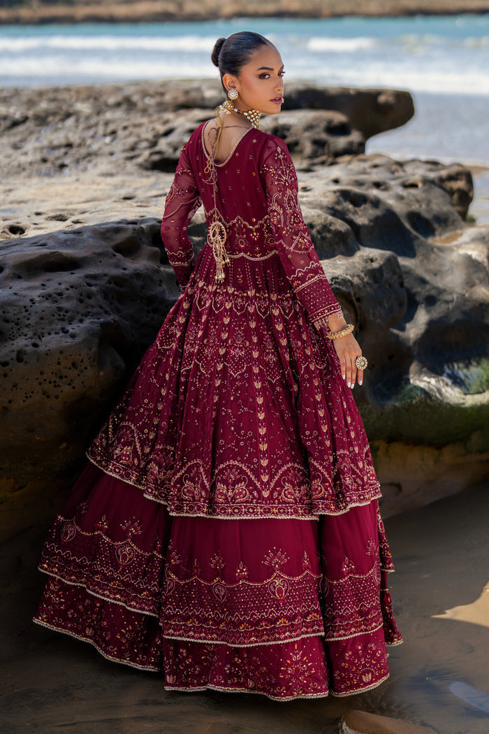 Model wearing full NAQSHI Zureal 3PC set: layered burgundy crinkle frock with heavy embroidery and tassels, raw-silk pants & matching embroidered dupatta styled for evening elegance.